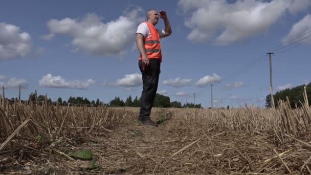 Фермер на солом'яному полі влітку — стокове відео