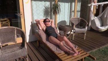 Bungalov yakınındaki şezlong içinde uyuyan kadın