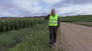 Mısır field yakınındaki akıllı telefonda konuşurken çiftçi