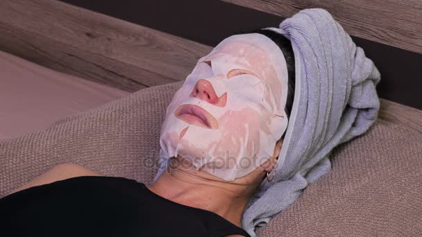Жінка спить і перевіряє маску для обличчя — стокове відео