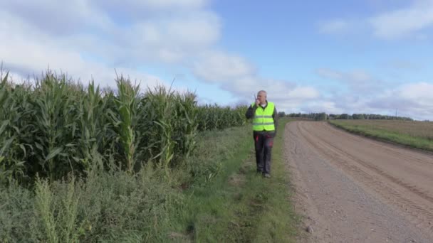 Фермер по рации говорит на краю кукурузного поля — стоковое видео