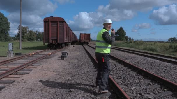 Työntekijä puhuu rautateillä ja kävelee pois — kuvapankkivideo