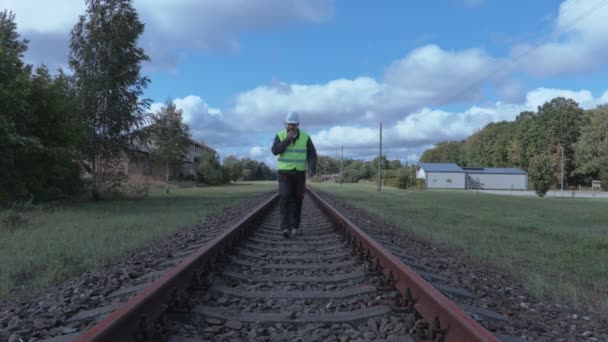 Railway employee with walkie talkie on rails — Stock Video