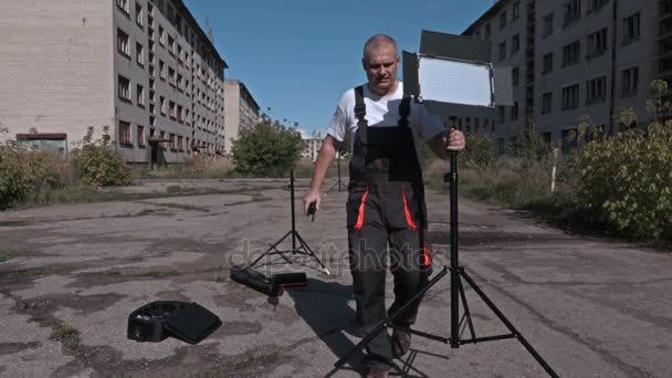 Travailleur avec talkie walkie et conduit des stands de lumière — Video