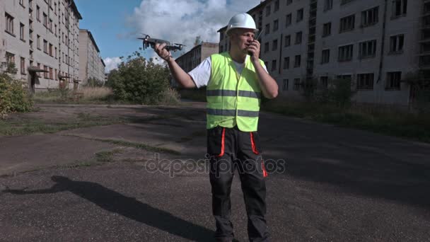 Arbetstagaren använder walkie talkie och hålla drone — Stockvideo