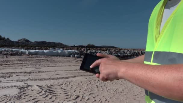 Építője használja a tabletta az építkezésen pier közelében — Stock videók