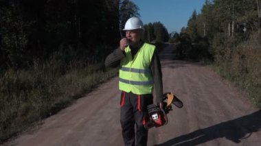 Kırık ve düşmüş Ladin yakınındaki yolda walkie talkie kullanarak orman işçisi