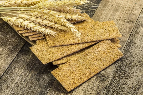 Stack of wholegrain crispy bread with wheat — Stock Photo, Image