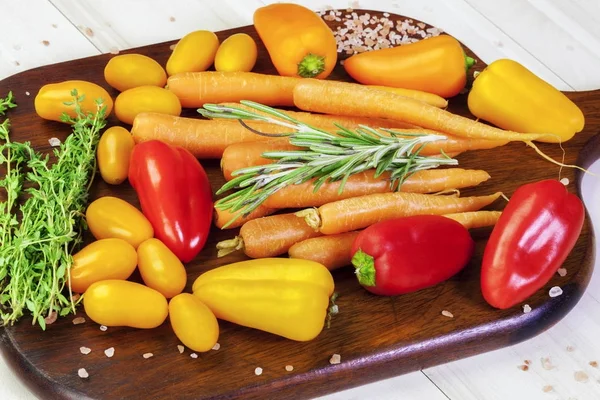 Peppers, tomatoes, carrots, thyme, basil on a table — Stock Photo, Image