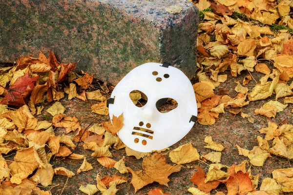 Ijesztő Halloween maszk közötti őszi levelek — Stock Fotó