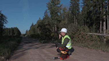 Orman yolu üzerinde chainsaw yakınındaki telefonda konuşurken orman işçisi