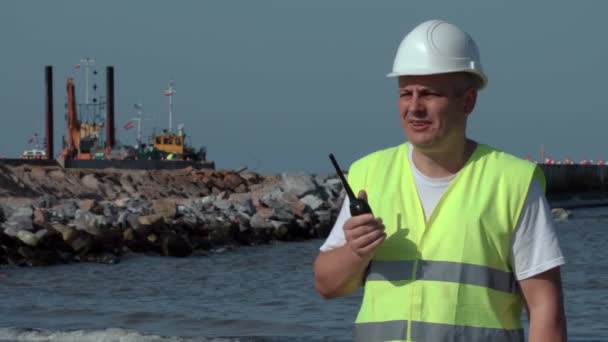 Engineer on walkie talkie on the seaside — Stock Video