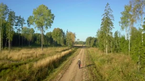 Camera vliegt over bosbouw werknemer op de weg — Stockvideo