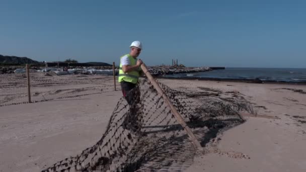 Arbetaren återställa staketet nära pier — Stockvideo
