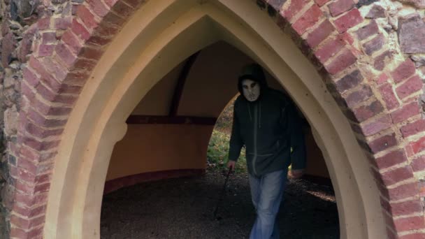 怖いハロウィーンのマスクとマチェーテ古いゲート付近の男 — ストック動画