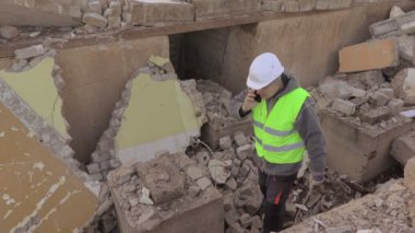 Harabeleri binasında akıllı telefonda konuşurken elektrikçi