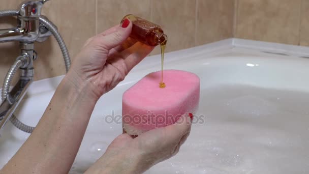 Frau legte Shampoo auf Schwamm