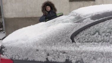Fırça car yakınındaki kar yağışı kullanan kadın