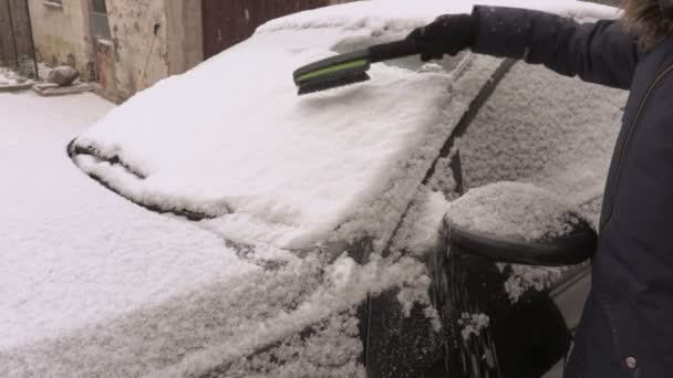 Frau Bei Schneetreiben Mit Bürste Neben Auto — Stockvideo