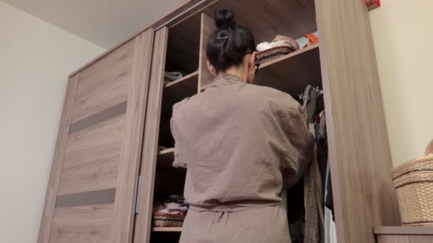 衣柜附近的女人选择她的时装套装 — 图库视频影像