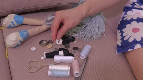 妇女缝制老玩偶在沙发上 — 图库视频影像