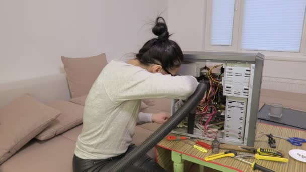 Frau benutzt Staubsauger in der Nähe eines kaputten Computers