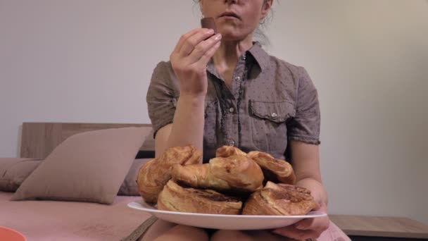 Woman eating junk food and watching Tv