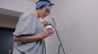 Kahve ve boya rulo fırça merdivenlerde bir kadınla