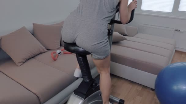 Femme Faisant Des Exercices Pour Les Fesses Sur Vélo Stationnaire — Video