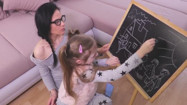 Mutter Und Tochter Zeichnen Haus Und Familie Auf Tafel — Stockvideo