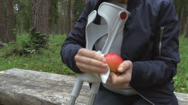 Mujer Discapacitada Con Muletas Limpiando Manzana Parque Banco — Vídeos de Stock