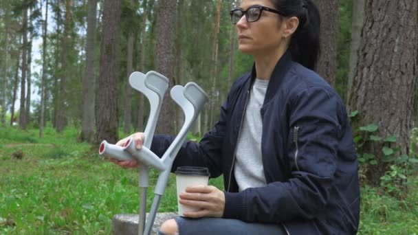 Disabled Female Crutches Drinking Coffee Park Bench — Stock Video