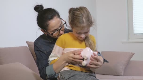 Madre Hija Con Alcancía Rosa — Vídeo de stock