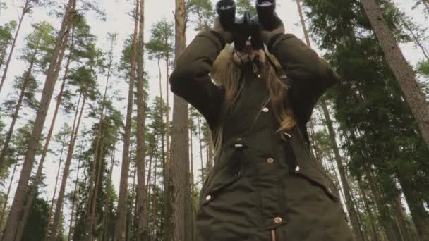 女孩拿着双筒望远镜看着树梢 探索者与冒险的概念 — 图库视频影像
