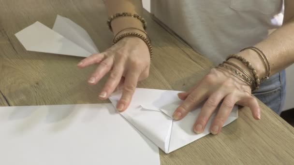 Woman Stroking Folds Paper Origami Airplane — Stock Video