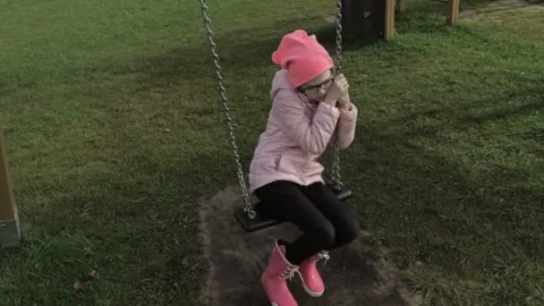 Λυπηρό Κορίτσι Στις Κούνιες Στη Δημόσια Παιδική Χαρά — Αρχείο Βίντεο