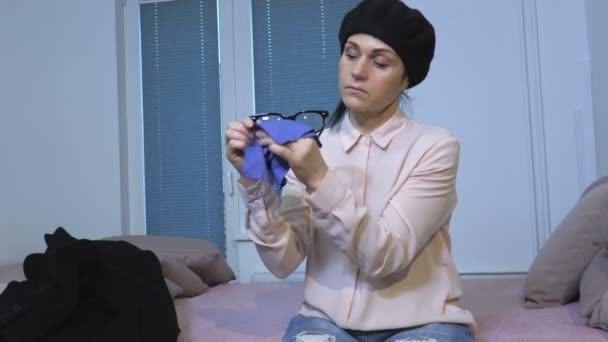 Γυναίκα Κάθεται Στο Κρεβάτι Και Γυαλιά Καθαρισμού — Αρχείο Βίντεο