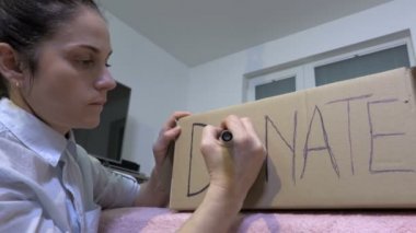 Bağış Konsepti. Karton bağış kutusunun yanındaki kadın