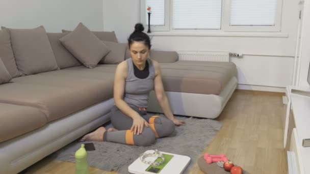 女人通过智能手机锻炼减肥 并尝试去做 减肥的概念 — 图库视频影像