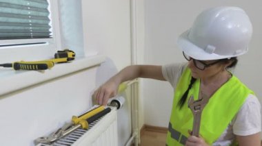 Kadın Tesisatçı kurulum radyatörünü bitiriyor