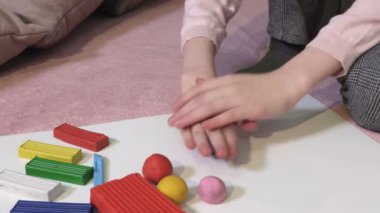 Kızın ellerini kağıt peçeteyle temizleyen kadın.