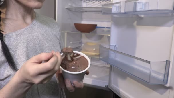 Γυναίκα Τρώει Πουτίγκα Σοκολάτας Κοντά Άδειο Ψυγείο — Αρχείο Βίντεο