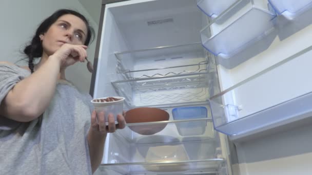 Mujer Pie Comiendo Nevera Vacía Abierta — Vídeos de Stock