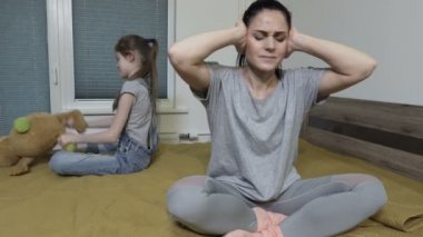 Şok olmuş anne, küçük inatçı kızı duymamak için kulaklarını kapatıyor.