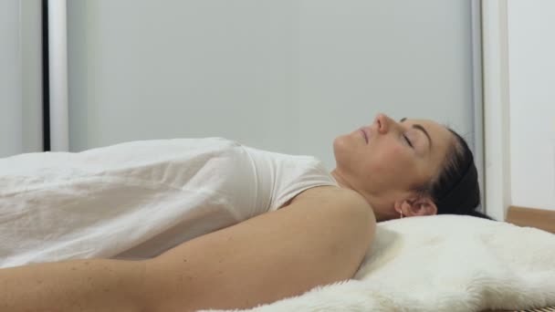 Γυναίκα Ξαπλωμένη Και Χαλαρωτική Κοντά Στην Καύση Κερί — Αρχείο Βίντεο