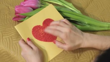 El yapımı kart ve bir buket lale ile mutlu bir anne.