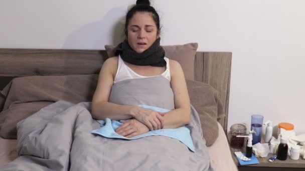 喉が痛いベッドに寝そべっている病気の女性 彼女は冷たくて鼻な鼻がある — ストック動画