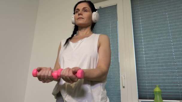 女人用小哑铃锻炼胳膊和肩膀 — 图库视频影像