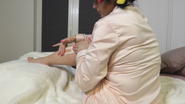 Kobieta Łóżku Woskuje Nogi Materiał Filmowy — Wideo stockowe