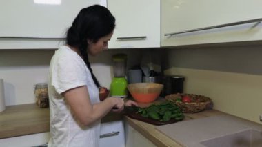 Yeşil smoothie için ıspanak dilimleyen kadın.